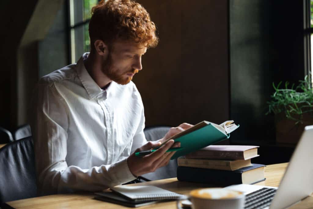photo concentrated redhead bearded student preparing university exam cafe photo concentrated redhead bearded student preparing university exam cafe