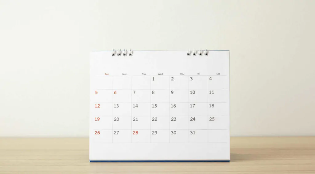 calendar page close up wood table with white wall background business planning appointment meeting concept scaled